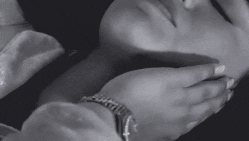 a black and white photo of a woman wearing a rolex watch