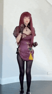 a woman in a purple dress and black tights is standing in a room with her eyes closed .