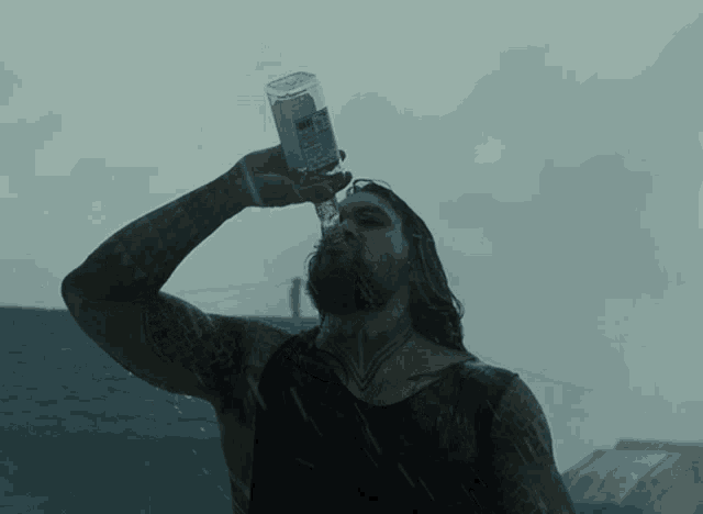 a man drinking from a bottle that says ' aquafina ' on the label