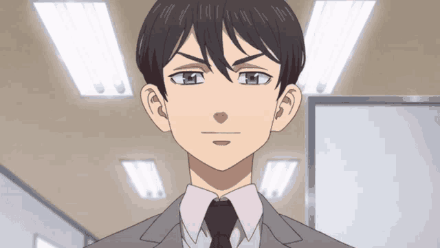 a man in a suit and tie looks at the camera with a serious look on his face