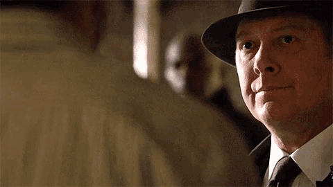a man wearing a hat and a tie looks to the side