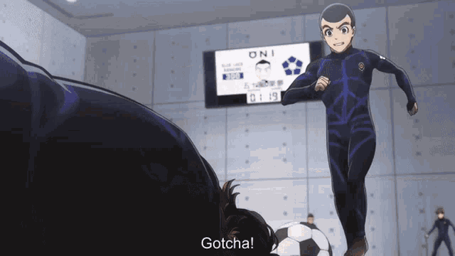 a man in a black suit is kicking a soccer ball while another man says gotcha