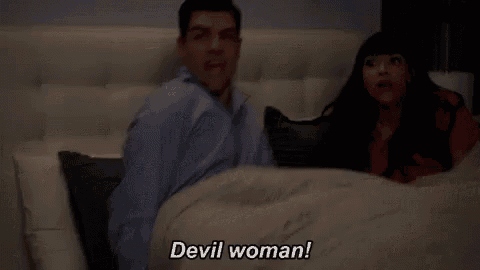 a man and a woman are laying in bed and the woman is screaming devil woman .