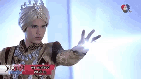 a man in a turban is holding a light in his hand