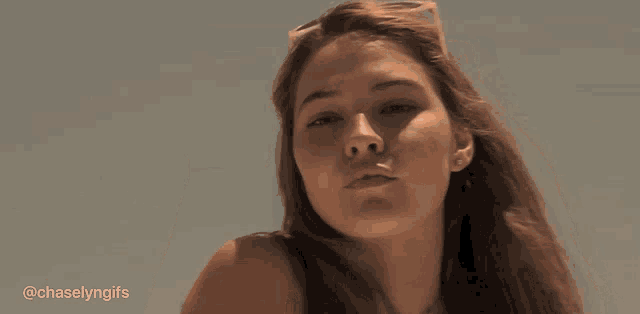 a woman wearing sunglasses holds her hand to her forehead and says chaselynngifs