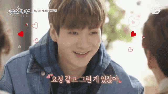a young man is smiling and surrounded by hearts and says " nutest " on the bottom