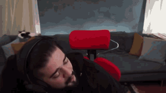 a man wearing headphones is laying on a chair