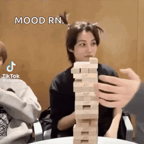 a person is holding a stack of wooden blocks .