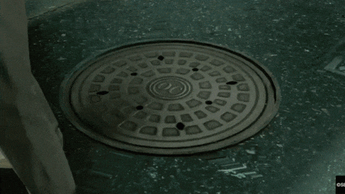a manhole cover with a cigarette sticking out of it and the word osb on the bottom