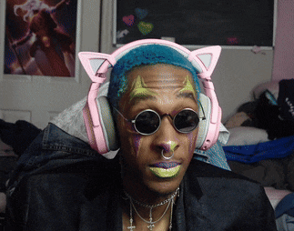 a man wearing pink headphones and sunglasses has a cross on his neck