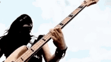 a woman is playing a guitar in the middle of a desert