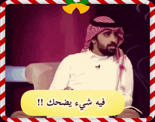 a man with a beard is sitting in a chair in front of a sign that says فيه شيء يضحك !!