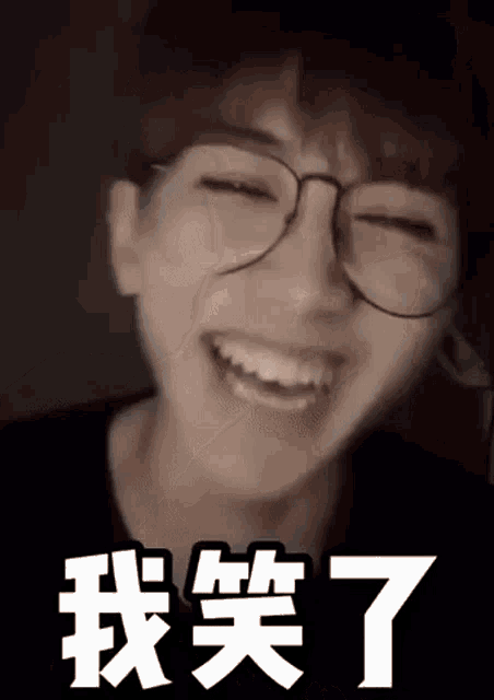 a close up of a person wearing glasses laughing with chinese writing .