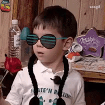 a young boy wearing sunglasses and a mickey mouse ear muff .