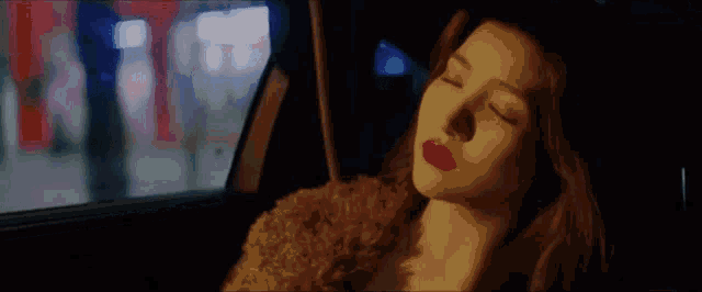 a woman with red lipstick is sitting in a car