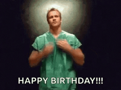 a man in a green scrub is dancing and saying `` happy birthday '' .