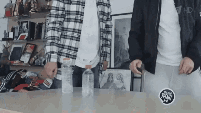 a man in a plaid shirt is holding a bottle of water .