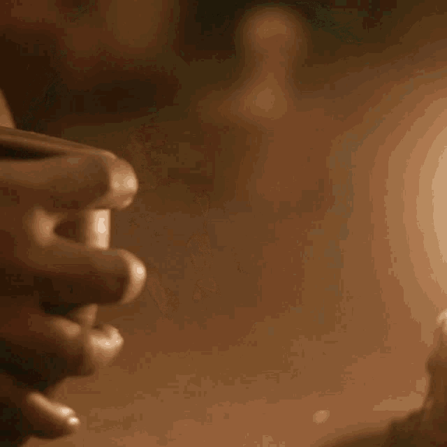a close up of a person holding a candle in their hand