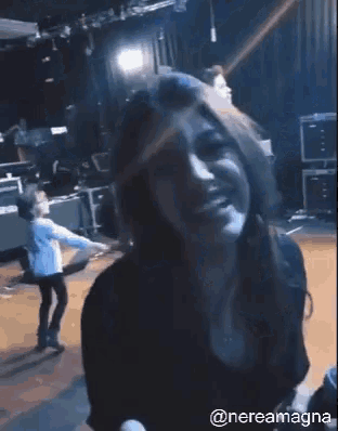 a woman is dancing in a dark room with the hashtag @nereamagna