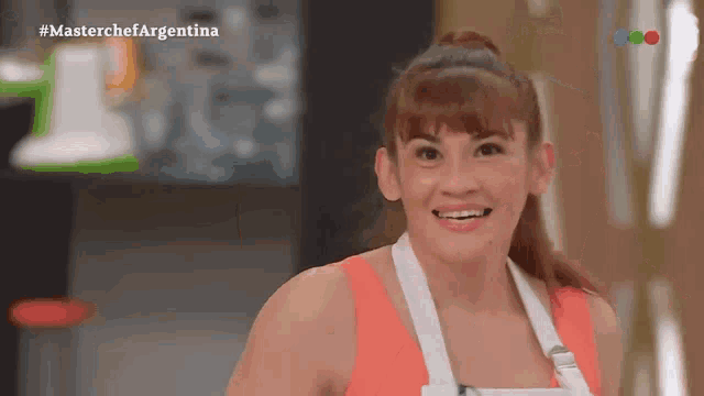 a woman is smiling in front of a screen that says masterchefargentina