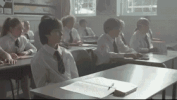 a group of children are sitting at desks in a classroom