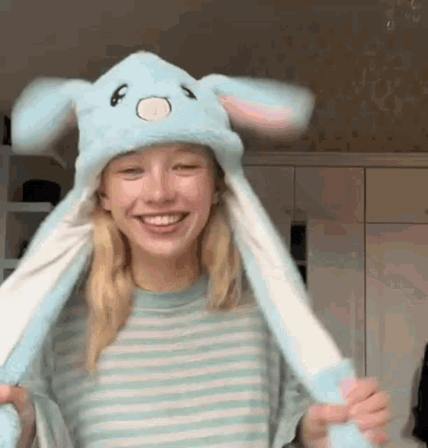a woman wearing a blue bunny hat with moving ears .