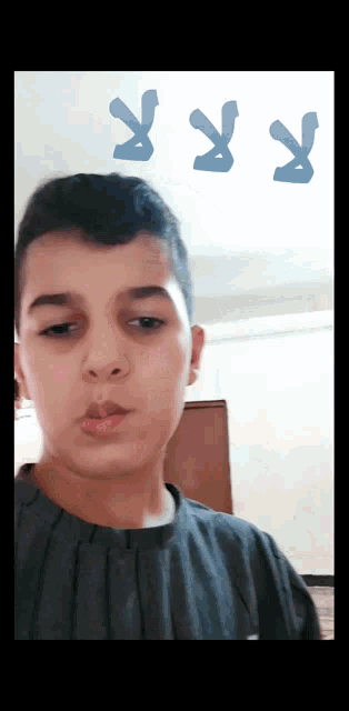 a young boy looks at the camera with the letters r x and y behind him