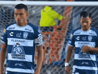 two soccer players wearing jerseys that say playdoit