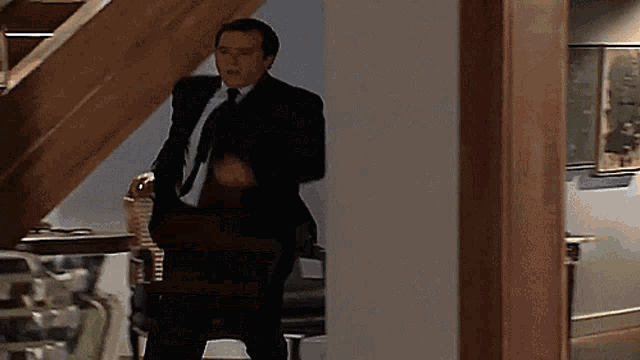 a man in a suit and tie stands in a hallway