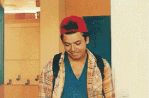 a young man wearing a plaid shirt and a red hat