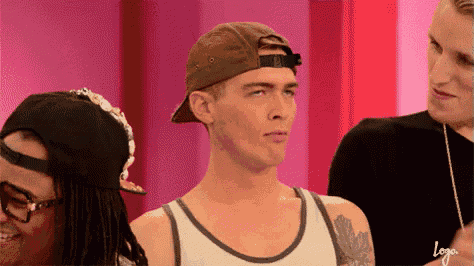 a man wearing a baseball cap and a tank top is standing next to two other men