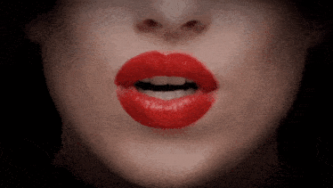 a close up of a woman 's mouth with red lipstick