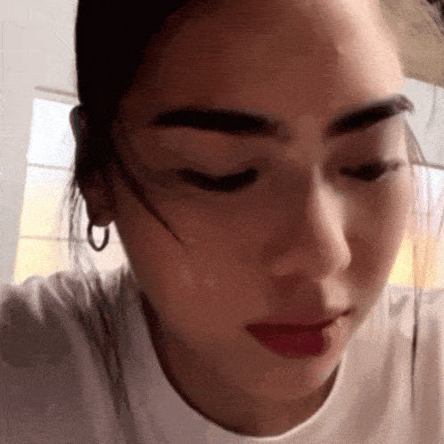 a close up of a woman 's face wearing a white shirt