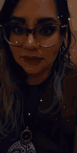 a woman wearing glasses and a red shirt has a necklace around her neck