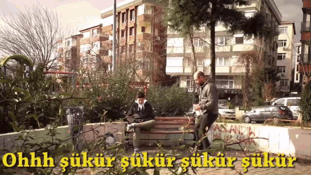 two men sit on a bench in a park with the words ohhh sukur sukur sukur