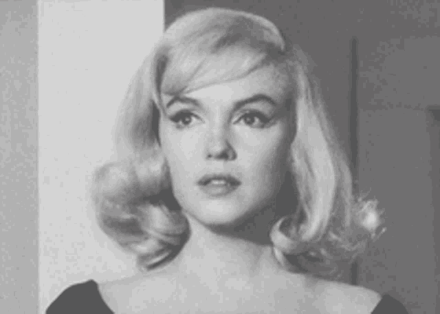 a woman with blonde hair is wearing a black top