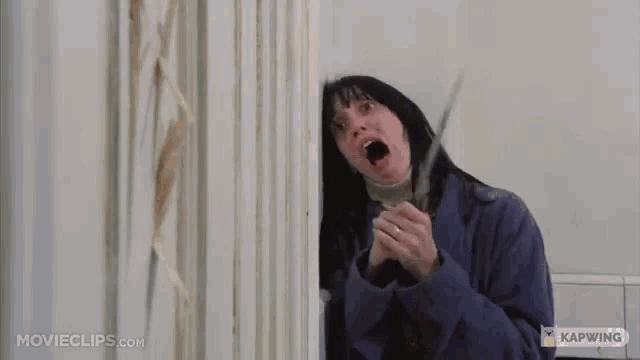 a woman in a purple coat is holding a pair of scissors and screaming .