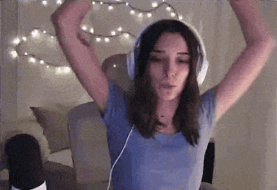 a woman wearing headphones is dancing in front of a microphone .