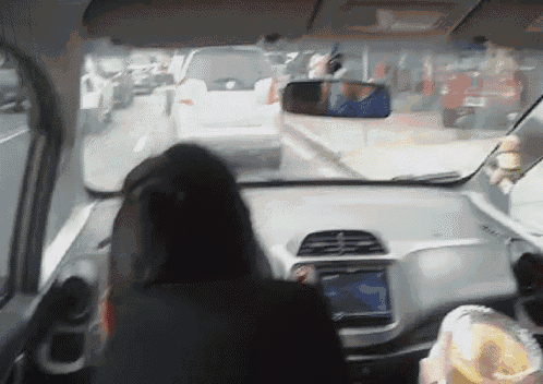 a person driving a car with a rear view mirror on