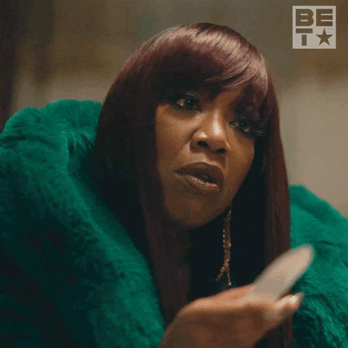 a woman with red hair is wearing a green fur coat and says i 'm serious