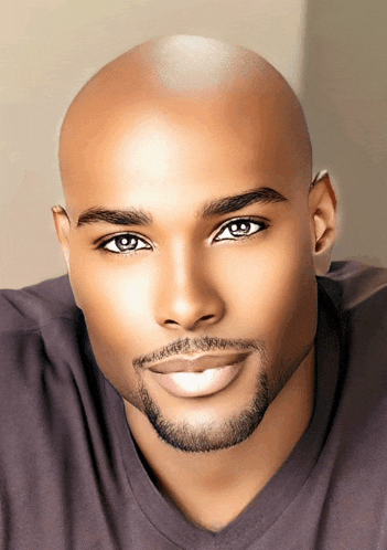 a bald man with a beard and blue eyes is smiling for the camera