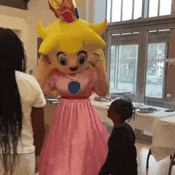 a mascot dressed as princess peach stands in front of a little girl