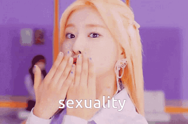 a woman with blonde hair is covering her mouth with her hands and the word sexuality is written above her