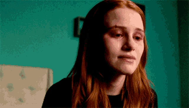 a close up of a woman 's face with tears coming out of her eyes .