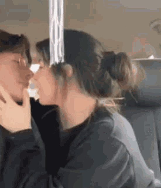 a woman is kissing a man on the cheek in a car .