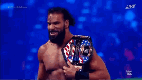 a man with a beard is wearing a wrestling belt .