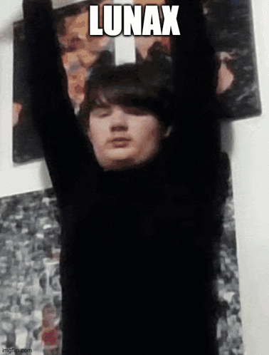 a man in a black turtleneck is hanging upside down on a wall .
