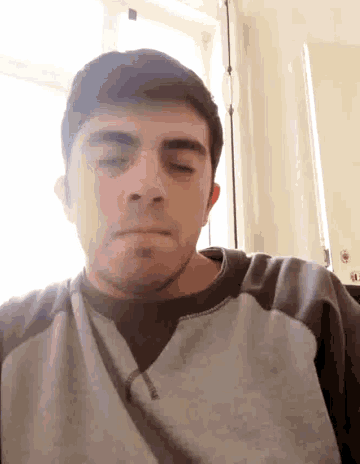 a man with his eyes closed wearing a grey sweatshirt with the word columbia on it