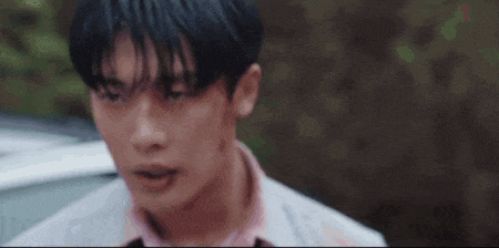 a close up of a young man 's face with a car in the background