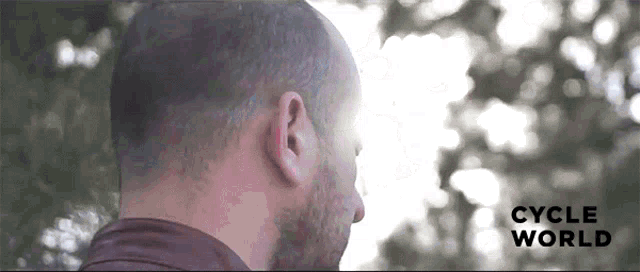 a man 's head is shown with the words cycle world visible behind him